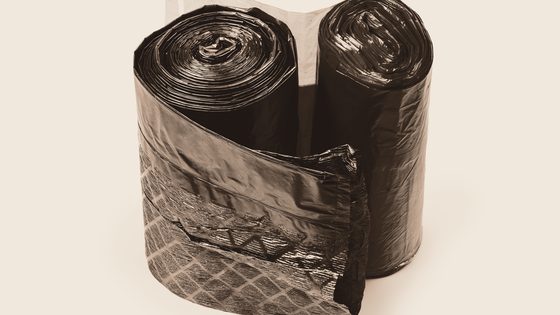 Stabel med fylte plastsekker i industrilokale, tonet i Bercos farger.